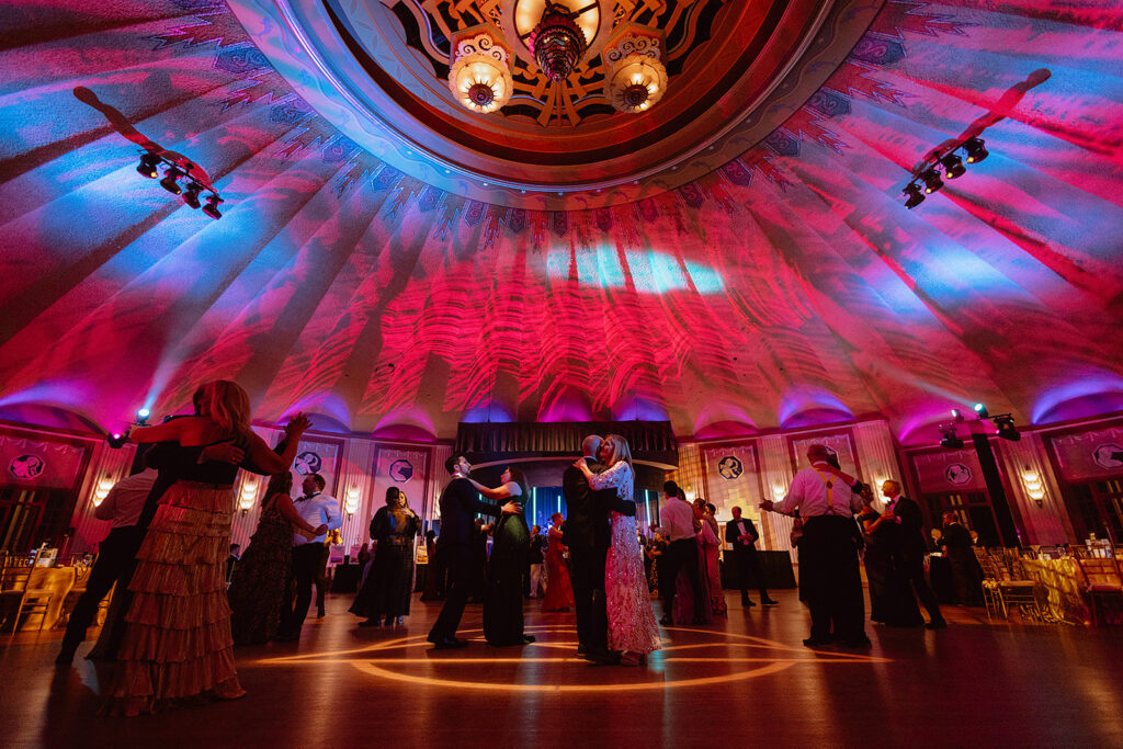 Catalina Island Conservancy Annual Ball 2026 - Catalina Island Conservancy Couples dance on a grand ballroom floor under a decorative domed ceiling with pink, purple, and blue lighting.